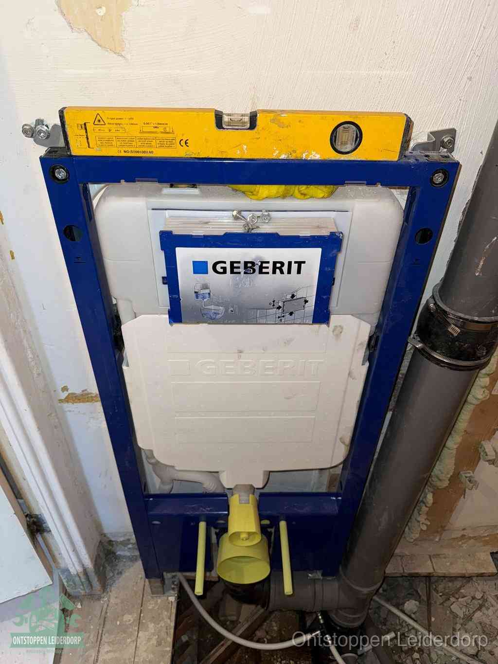 Een Geberit inbouwreservoir met frame voor een hangtoilet tegen de wand, met de afvoerbocht naar de vloer, kenmerkend voor een verstopt hangtoilet in Leiderdorp