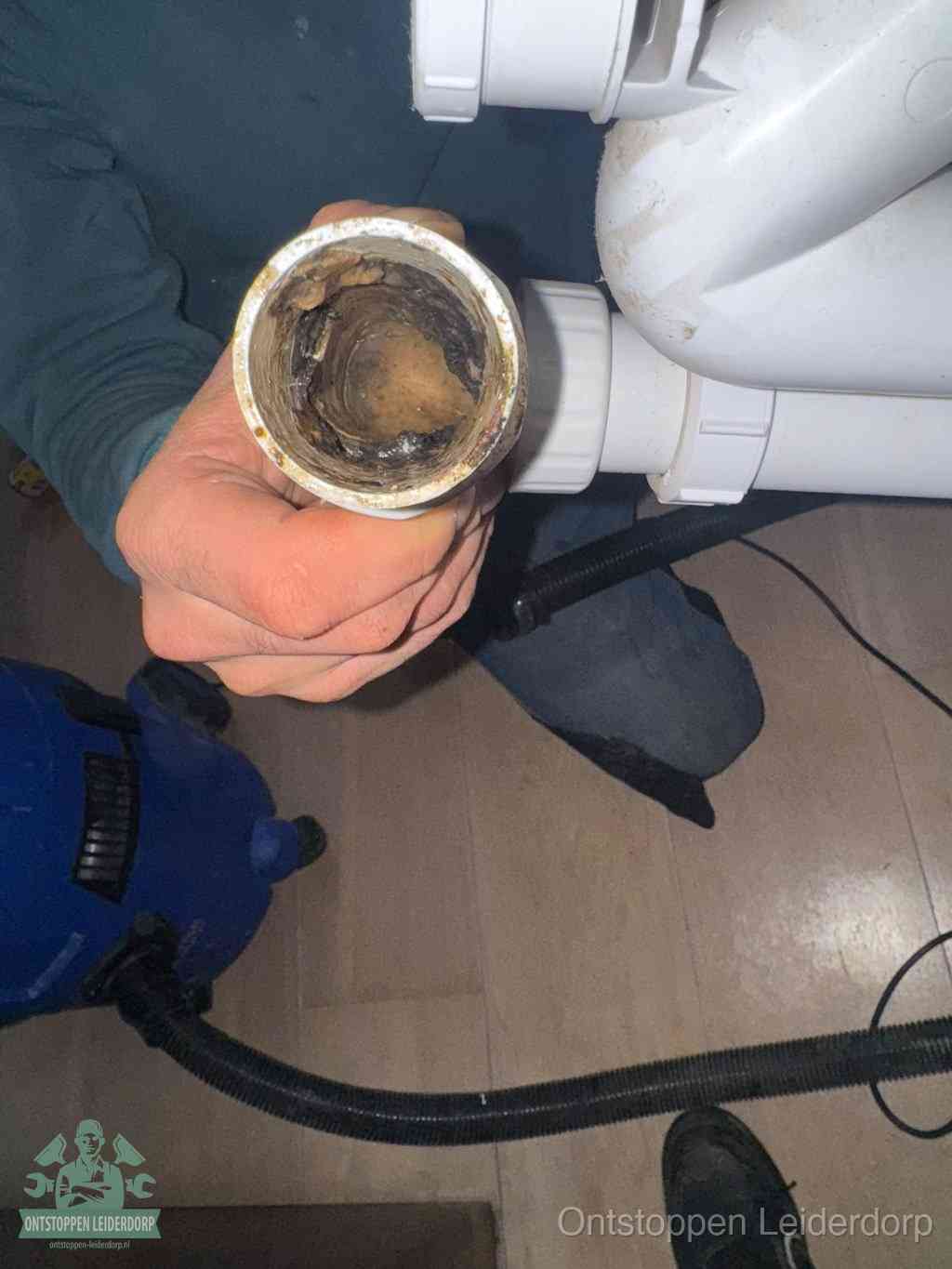 Een losgekoppelde afvoerbuis die van binnen volledig is dichtgeslibd met vet en aanslag, de meest voorkomende oorzaak van een verstopte gootsteen in Leiderdorp