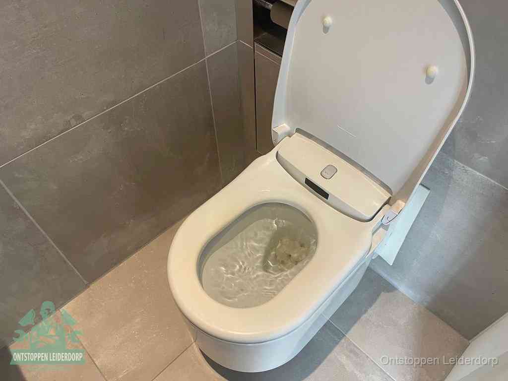 Een toiletpot vol troebel water met drijvend papier en restanten, de meest voorkomende oorzaak van een verstopte wc in Leiderdorp
