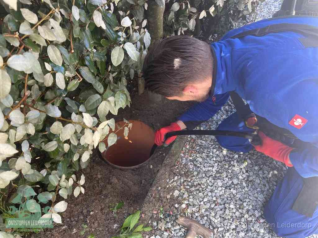 Monteur reinigt een rioolput met een slang, periodieke rioolreiniging in Leiderdorp