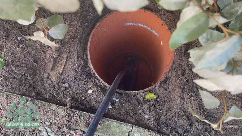 Open inspectieput in de tuin waar een veer rioolvliegjes en stankoverlast aanpakt in Leiderdorp