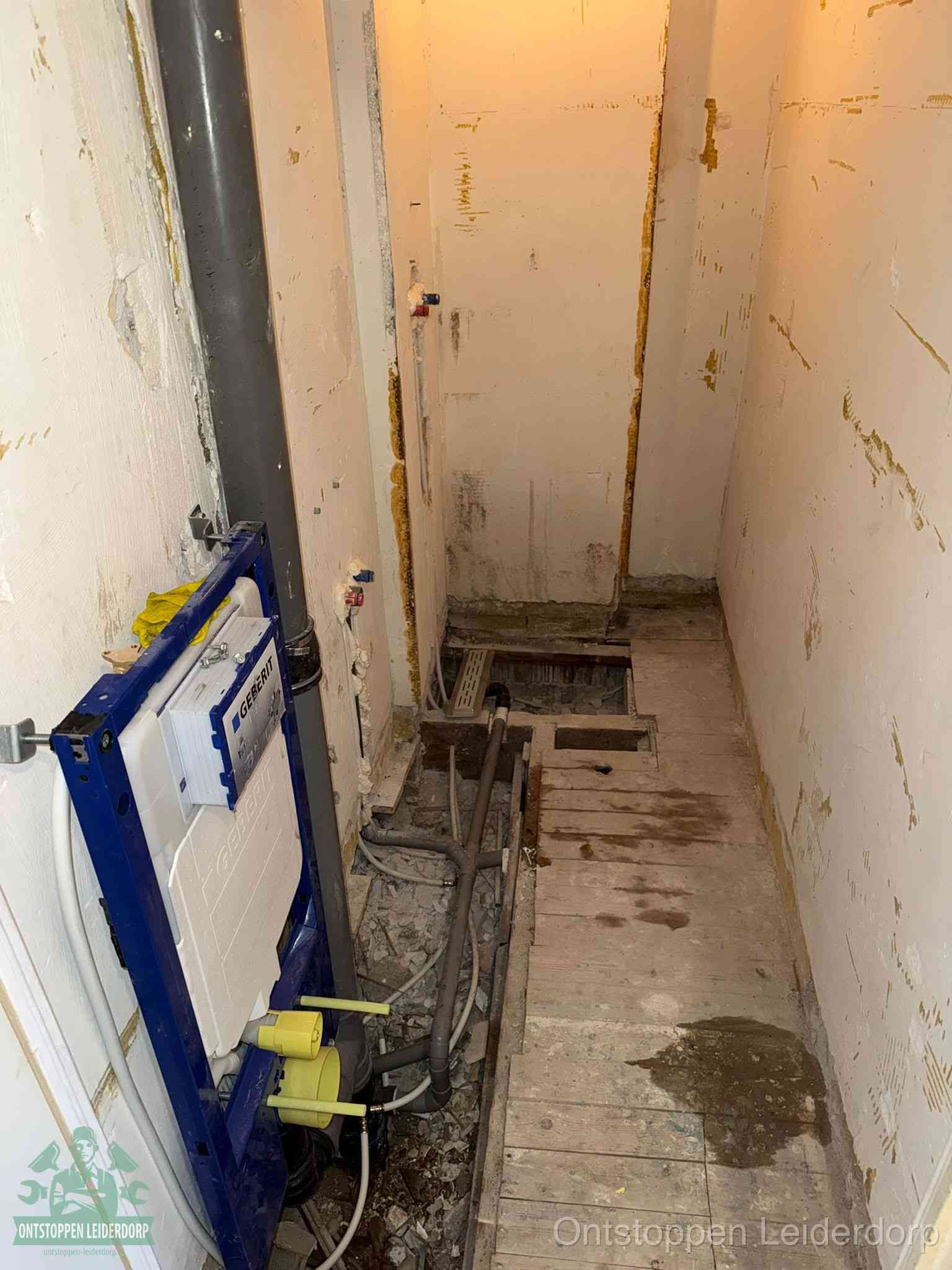 Een opgebroken toiletruimte tijdens renovatie met een Geberit inbouwreservoir en blootliggende oude afvoerleidingen, typisch voor oudere woningen in Leiderdorp